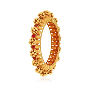 Golden ring adorned with floral motifs and red gemstones.