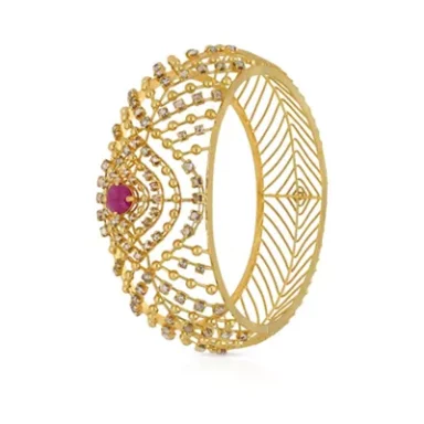 Gold bangle with intricate patterns and a central ruby stone.