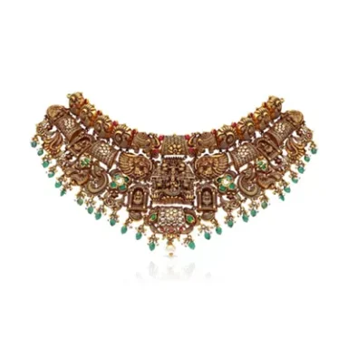 Intricate gold necklace with ornate designs and colourful gemstone accents.