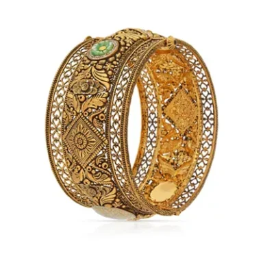 Intricately designed gold bangle with turquoise detail and ornate filigree patterns.