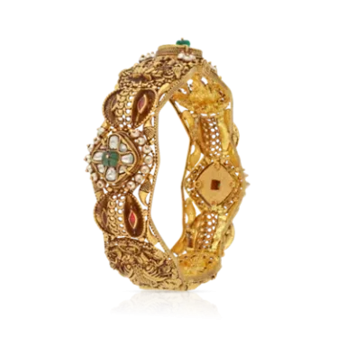 Intricately designed gold bangle with gemstones and detailed patterns.