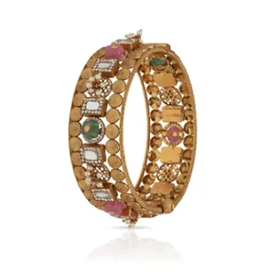 Gold bangle adorned with colourful gemstones and intricate designs.