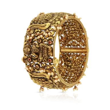Intricately designed gold bangle with floral patterns and decorative stones.