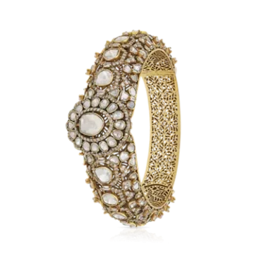 Intricate gold bangle adorned with pearls and floral motifs.
