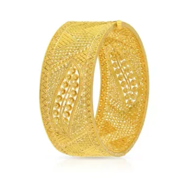 Intricately designed gold bangle with a patterned surface.