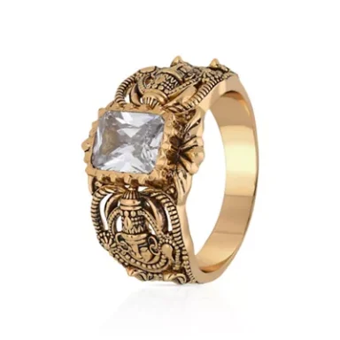 Gold ring with intricate floral patterns and a large rectangular clear stone.