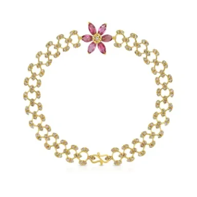 Gold bracelet featuring a floral design with pink gemstones.